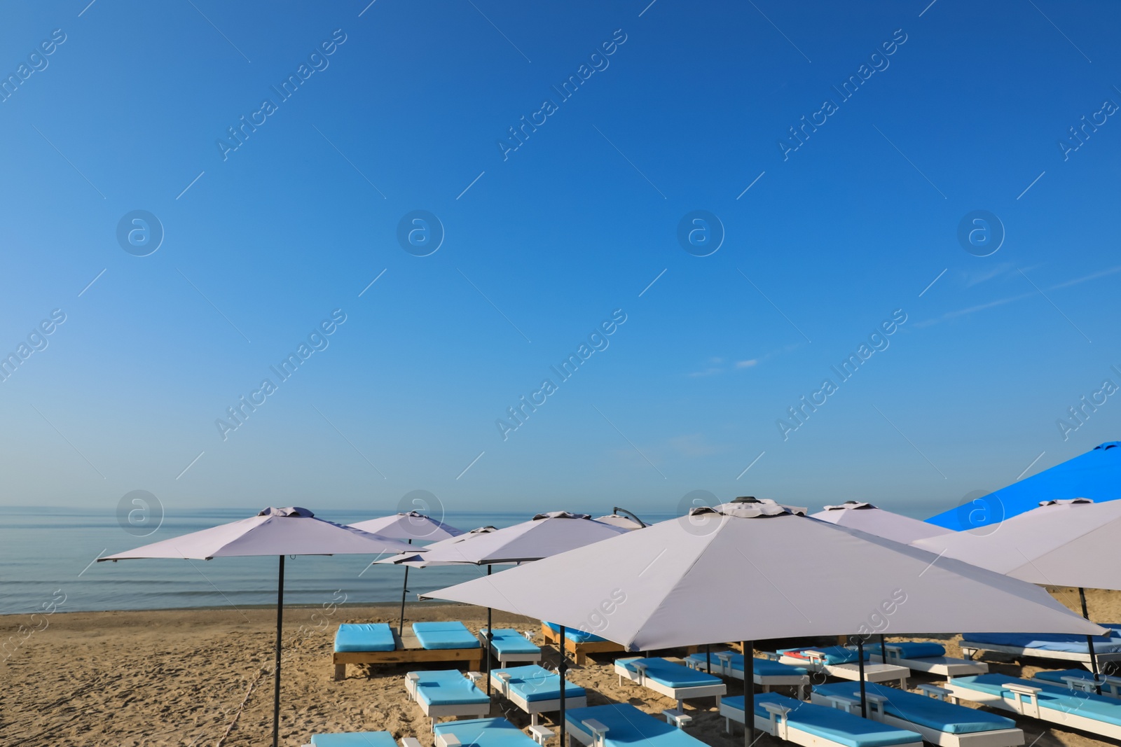Many beach umbrellas and sunbeds at resort Photo of Many beach umbrellas and sunbeds at resort