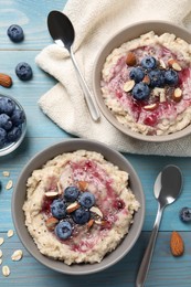 Tasty oatmeal porridge with toppings served on light blue wooden table, flat lay Photo of Tasty oatmeal porridge with toppings served on light blue wooden table, flat lay