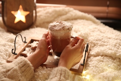Woman with cup of hot drink and Christmas cookies at home, closeup Photo of Woman with cup of hot drink and Christmas cookies at home, closeup