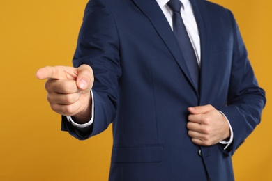 Businessman touching something on yellow background, closeup. Finger gesture Photo of Businessman touching something on yellow background, closeup. Finger gesture