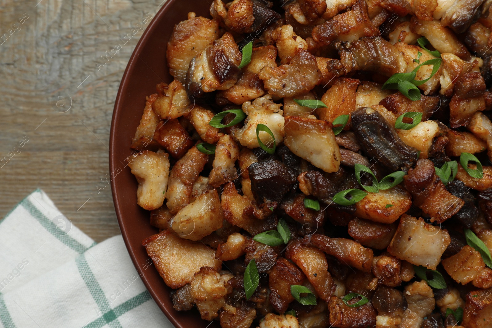 Tasty fried cracklings on wooden table, top view. Cooked pork lard Photo of Tasty fried cracklings on wooden table, top view. Cooked pork lard