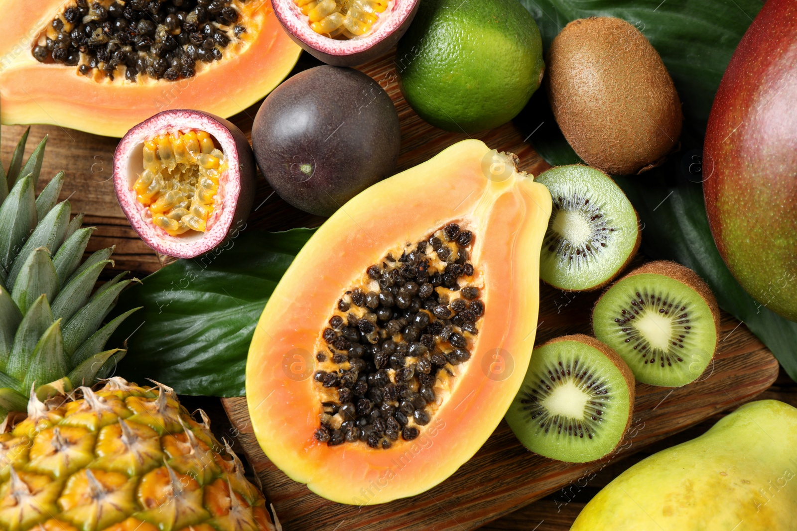 Fresh ripe papaya and other fruits on wooden table, flat lay Photo of Fresh ripe papaya and other fruits on wooden table, flat lay