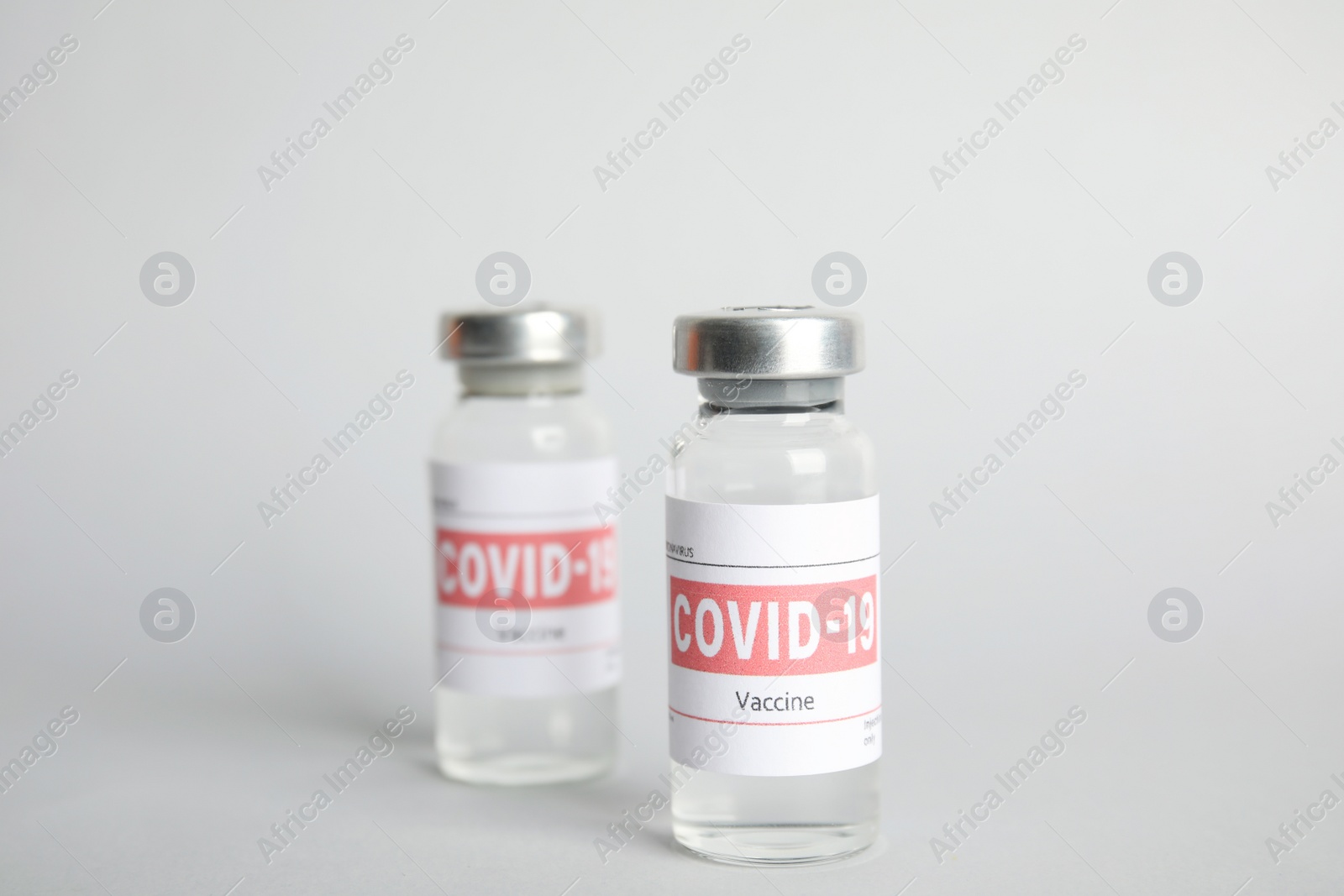 Vials with coronavirus vaccine on light background Photo of Vials with coronavirus vaccine on light background