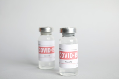 Vials with coronavirus vaccine on light background Photo of Vials with coronavirus vaccine on light background
