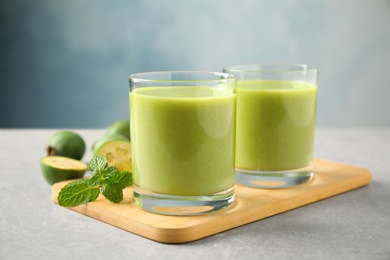 Fresh feijoa smoothie and fresh mint on grey table, closeup Photo of Fresh feijoa smoothie and fresh mint on grey table, closeup