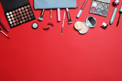 Decorative cosmetic products on red background, flat lay. Space for text Photo of Decorative cosmetic products on red background, flat lay. Space for text