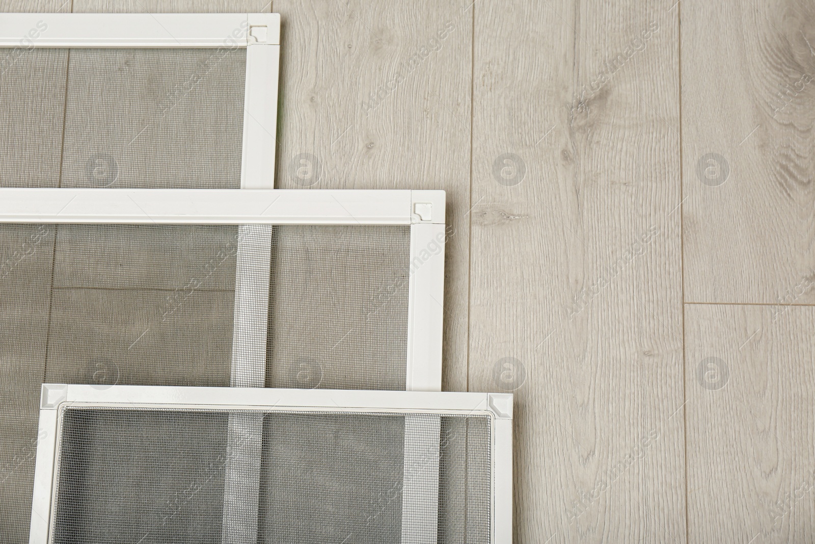 Set of window screens on wooden floor, flat lay. Space for text Photo of Set of window screens on wooden floor, flat lay. Space for text