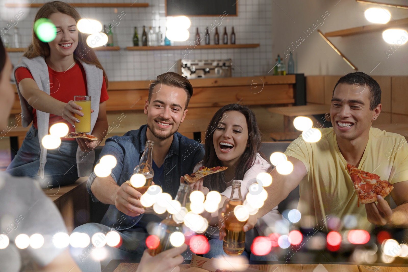 Group of friends having fun party with delicious pizza in cafe, bokeh effect Image of Group of friends having fun party with delicious pizza in cafe, bokeh effect