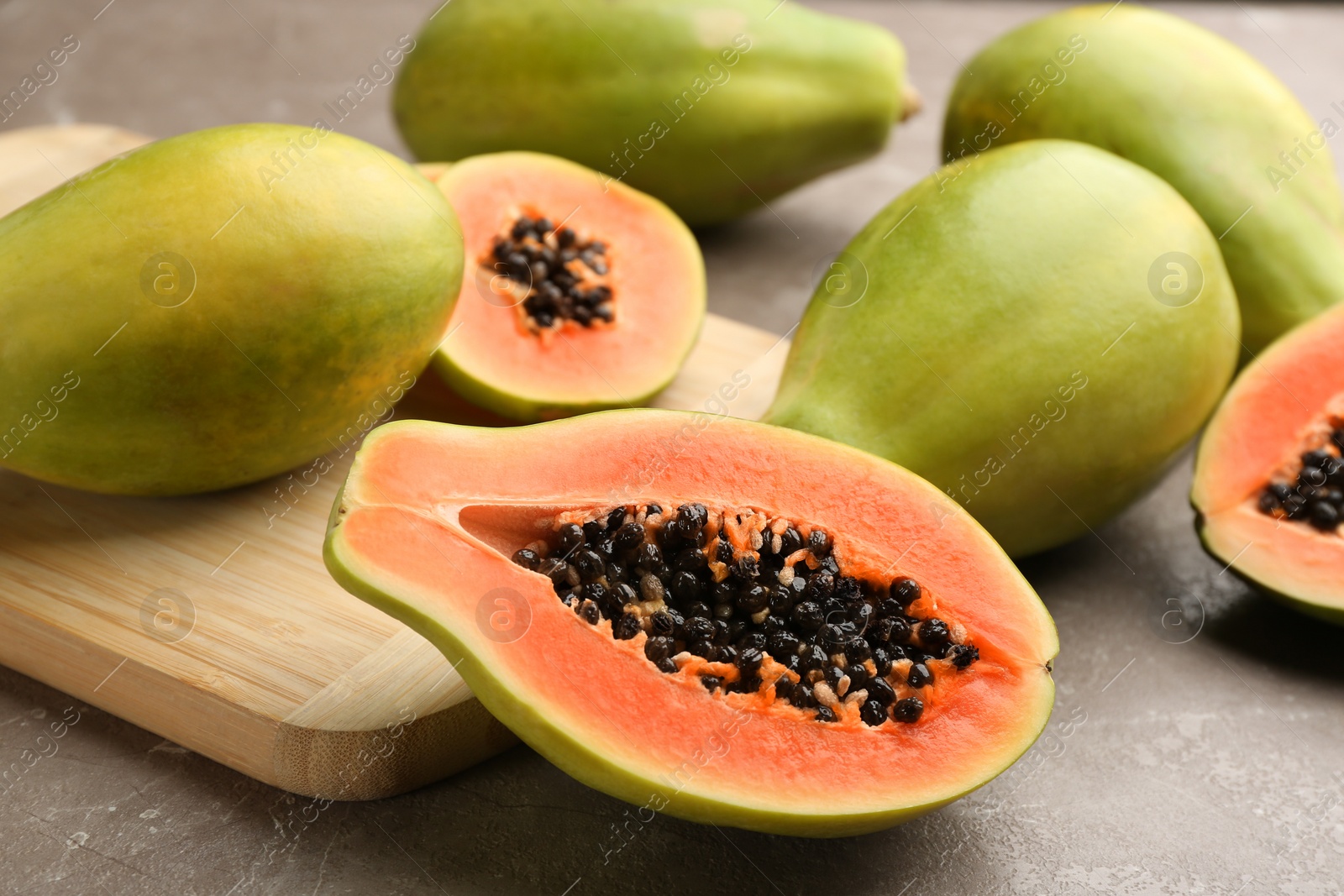 Fresh ripe papaya fruits on grey table Photo of Fresh ripe papaya fruits on grey table