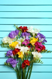 Beautiful freesia flowers on wooden background Photo of Beautiful freesia flowers on wooden background