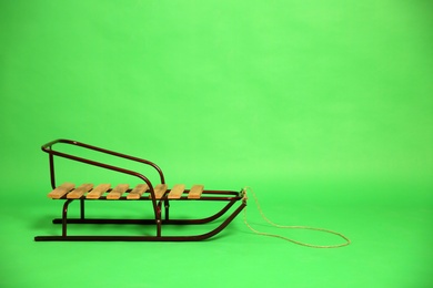Empty sleigh on green background. Space for text Photo of Empty sleigh on green background. Space for text