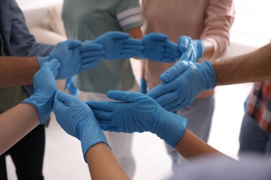 People in blue medical gloves showing circle with hands on light background, closeup Photo of People in blue medical gloves showing circle with hands on light background, closeup