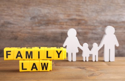 Cubes with letters and family figure on wooden table. Family law concept Image of Cubes with letters and family figure on wooden table. Family law concept
