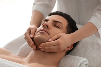 Man receiving facial massage in beauty salon Photo of Man receiving facial massage in beauty salon