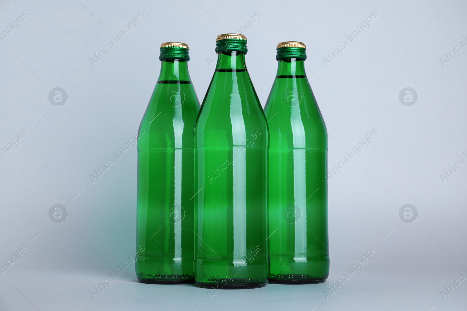 Glass bottles with water on white background Photo of Glass bottles with water on white background