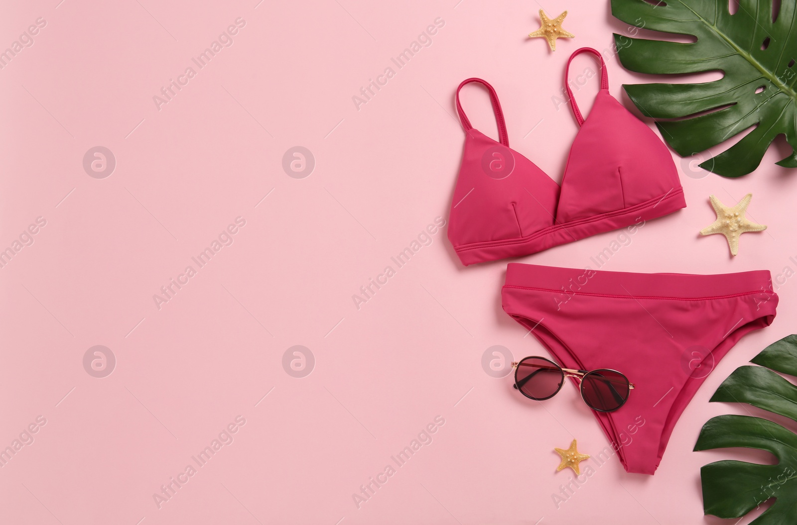 Stylish bikini and beach accessories on pink background, flat lay. Space for text Photo of Stylish bikini and beach accessories on pink background, flat lay. Space for text