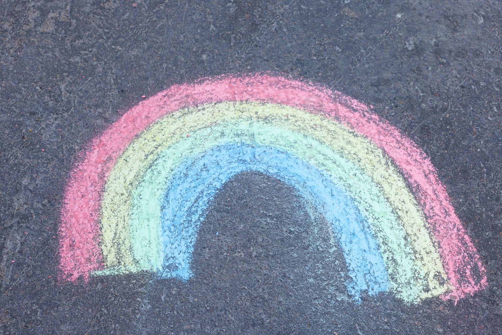 Child's chalk drawing of rainbow on asphalt, above view Photo of Child's chalk drawing of rainbow on asphalt, above view