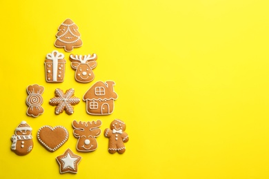 Delicious gingerbread cookies arranged in shape of Christmas tree on yellow background, flat lay. Space for text Photo of Delicious gingerbread cookies arranged in shape of Christmas tree on yellow background, flat lay. Space for text