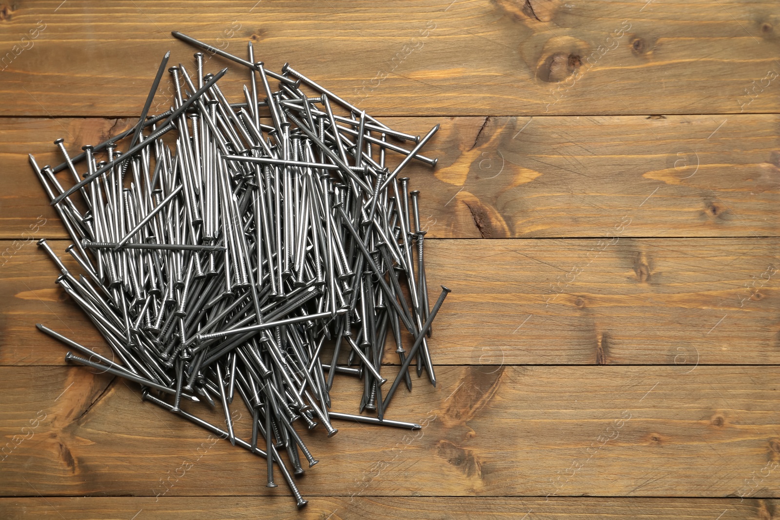 Many metal nails on wooden background, flat lay. Space for text Photo of Many metal nails on wooden background, flat lay. Space for text