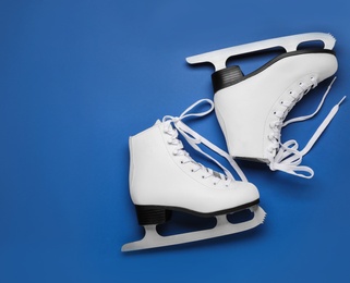 Pair of figure ice skates on blue background, flat lay. Space for text Photo of Pair of figure ice skates on blue background, flat lay. Space for text