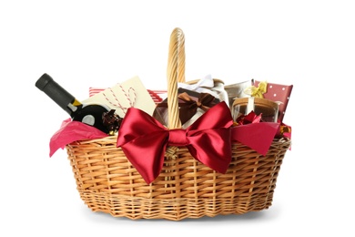 Wicker basket full of gifts isolated on white Photo of Wicker basket full of gifts isolated on white