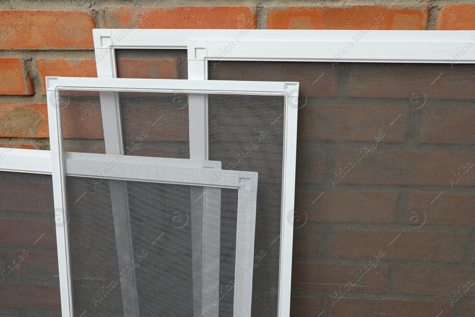 Set of window screens near brick wall Photo of Set of window screens near brick wall