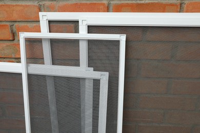 Set of window screens near brick wall Photo of Set of window screens near brick wall