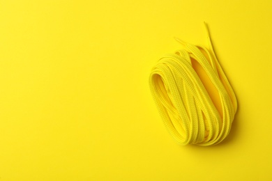 Shoelace on yellow background, top view. Space for text Photo of Shoelace on yellow background, top view. Space for text