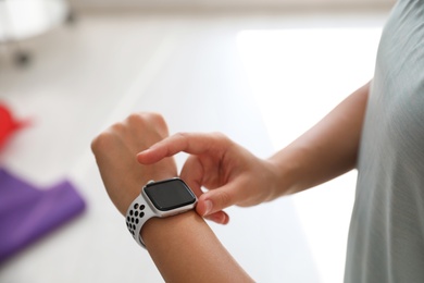 Woman checking fitness tracker in gym, closeup Photo of Woman checking fitness tracker in gym, closeup