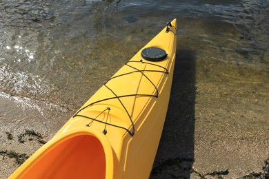 Yellow kayak on beach near river, closeup. Summer camp activity Photo of Yellow kayak on beach near river, closeup. Summer camp activity