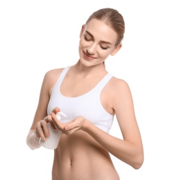 Young woman with bottle of body cream on white background Photo of Young woman with bottle of body cream on white background