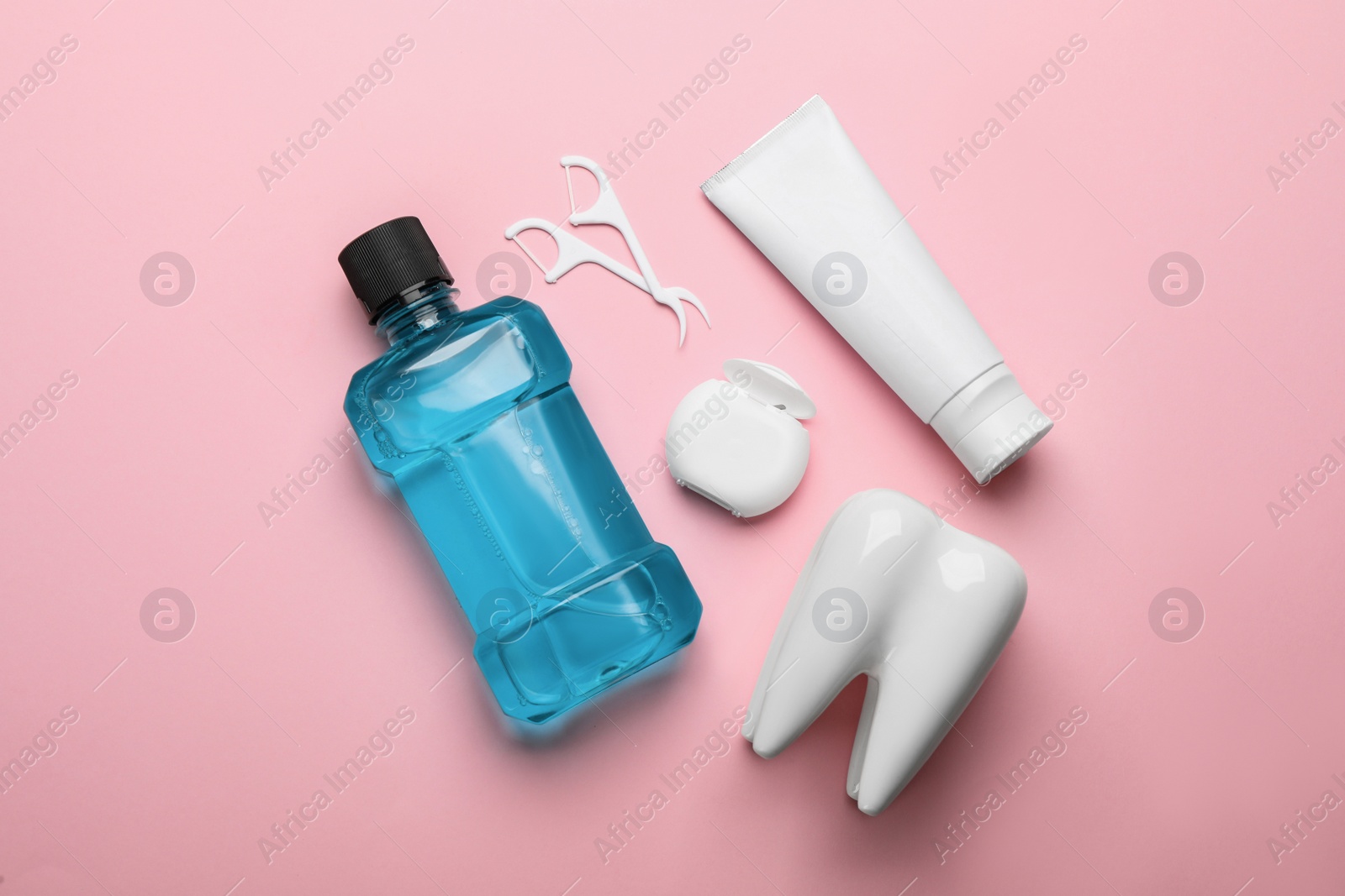 Flat lay composition with mouthwash and other oral hygiene products on pink background Photo of Flat lay composition with mouthwash and other oral hygiene products on pink background