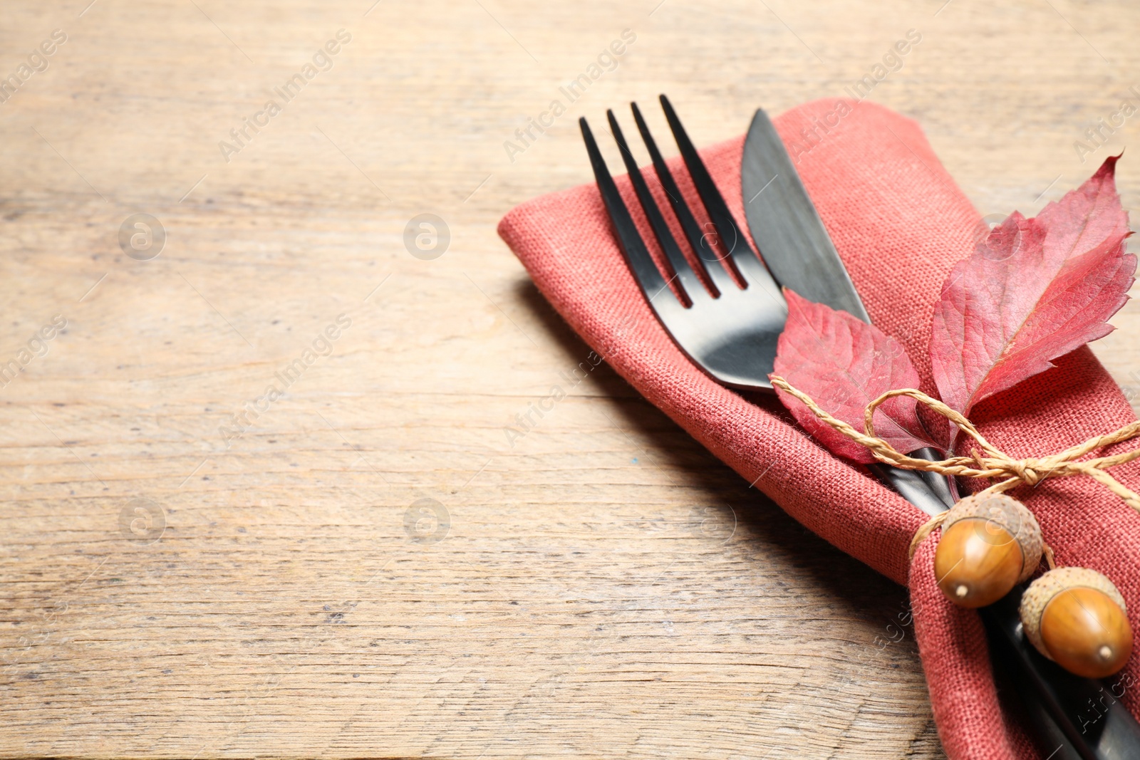 Cutlery with acorns, autumn leaves and napkin on wooden table, space for text. Thanksgiving Day Photo of Cutlery with acorns, autumn leaves and napkin on wooden table, space for text. Thanksgiving Day