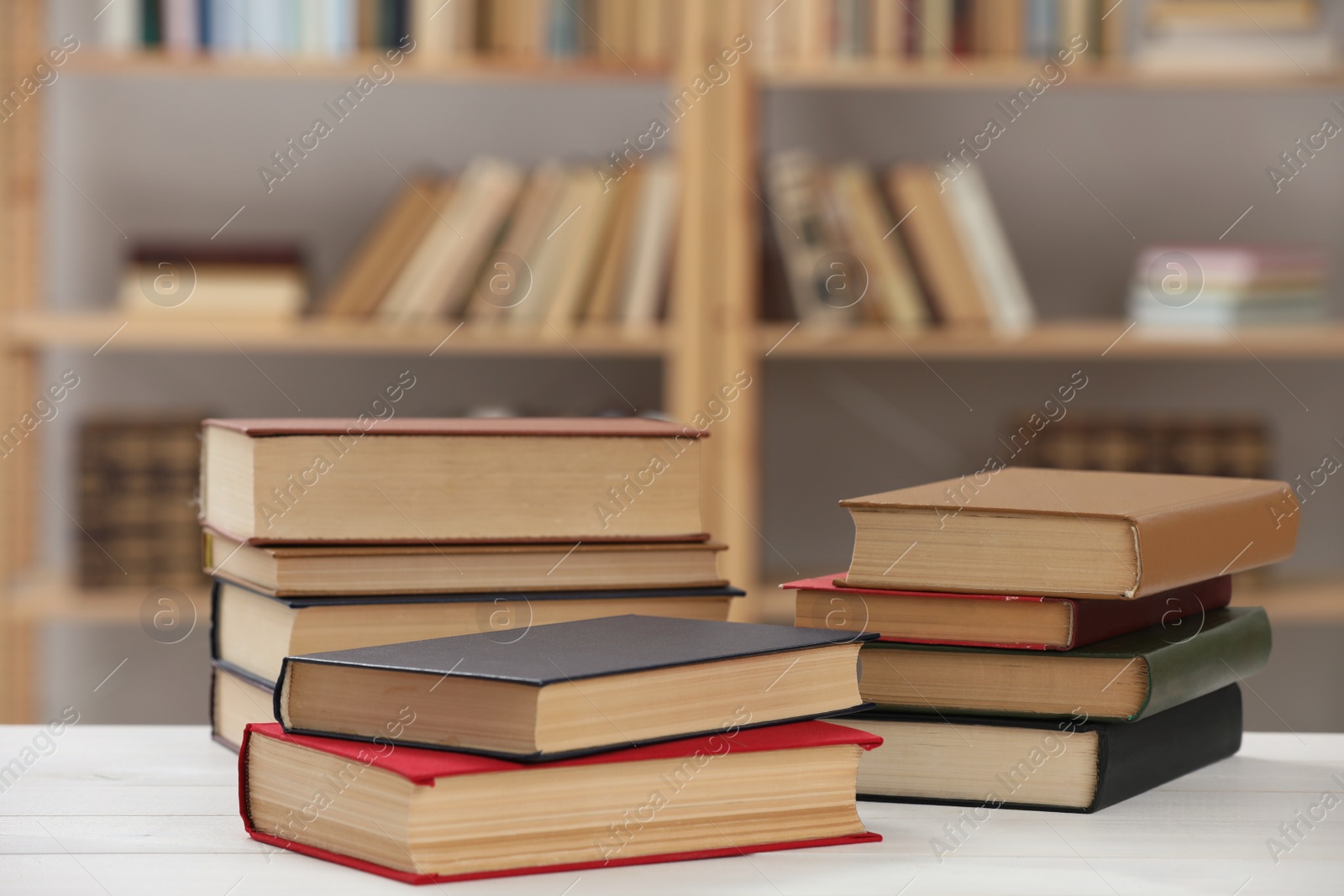 Many books on white table in library Photo of Many books on white table in library