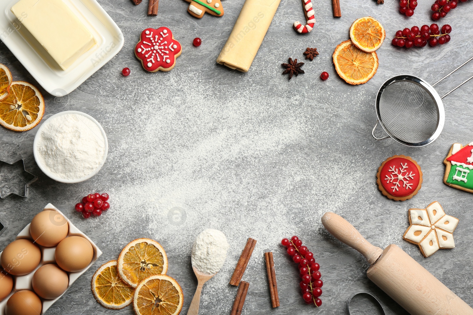 Frame of Christmas cookies and flour on grey table, flat lay. Space for text Photo of Frame of Christmas cookies and flour on grey table, flat lay. Space for text