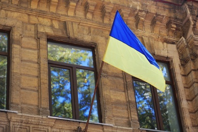 National flag of Ukraine on old building wall outdoors Photo of National flag of Ukraine on old building wall outdoors