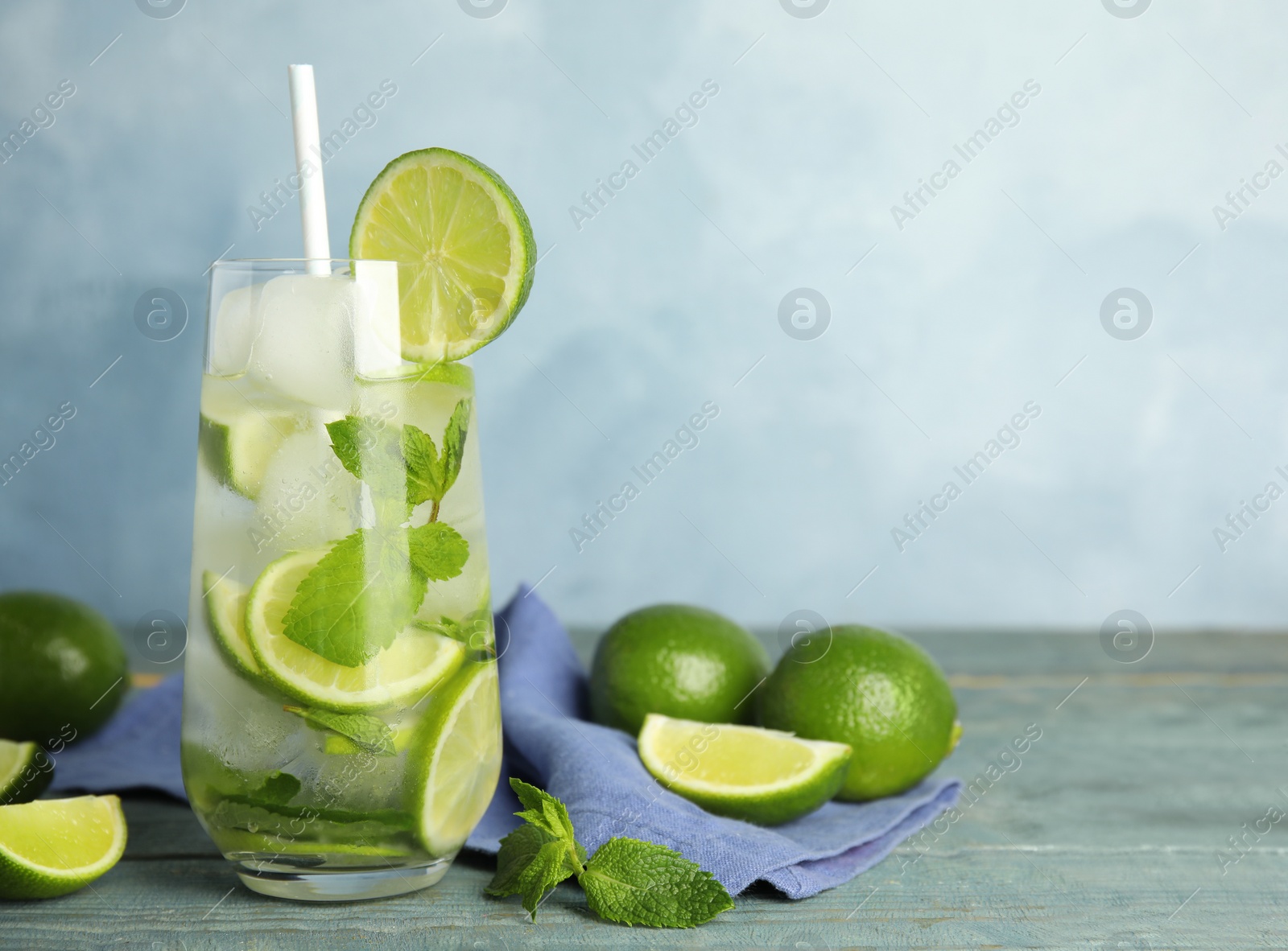Delicious mojito and ingredients on blue wooden table. Space for text Photo of Delicious mojito and ingredients on blue wooden table. Space for text