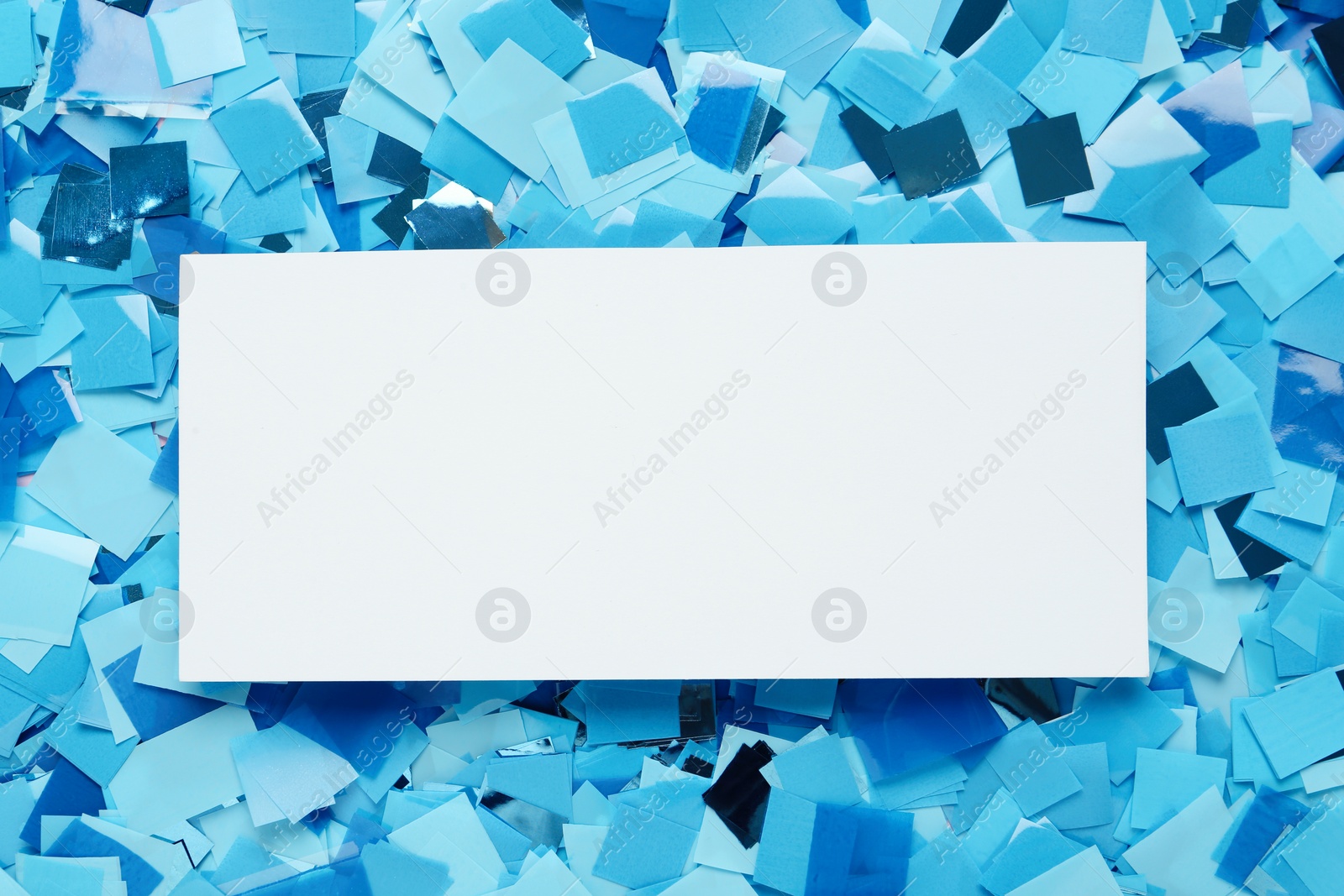 Card on light blue confetti, top view. Space for text Photo of Card on light blue confetti, top view. Space for text
