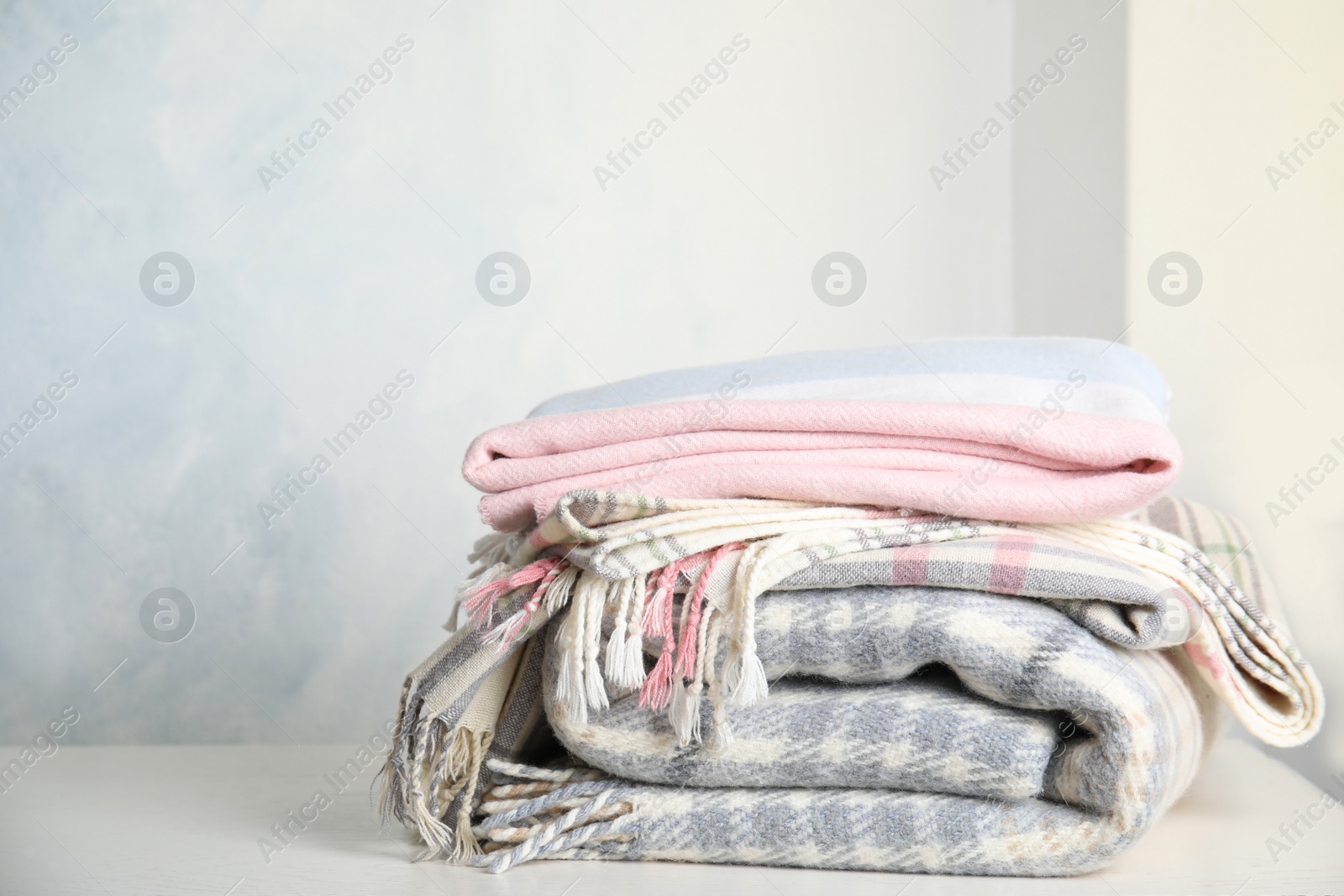 Stack of soft plaids on white table Photo of Stack of soft plaids on white table