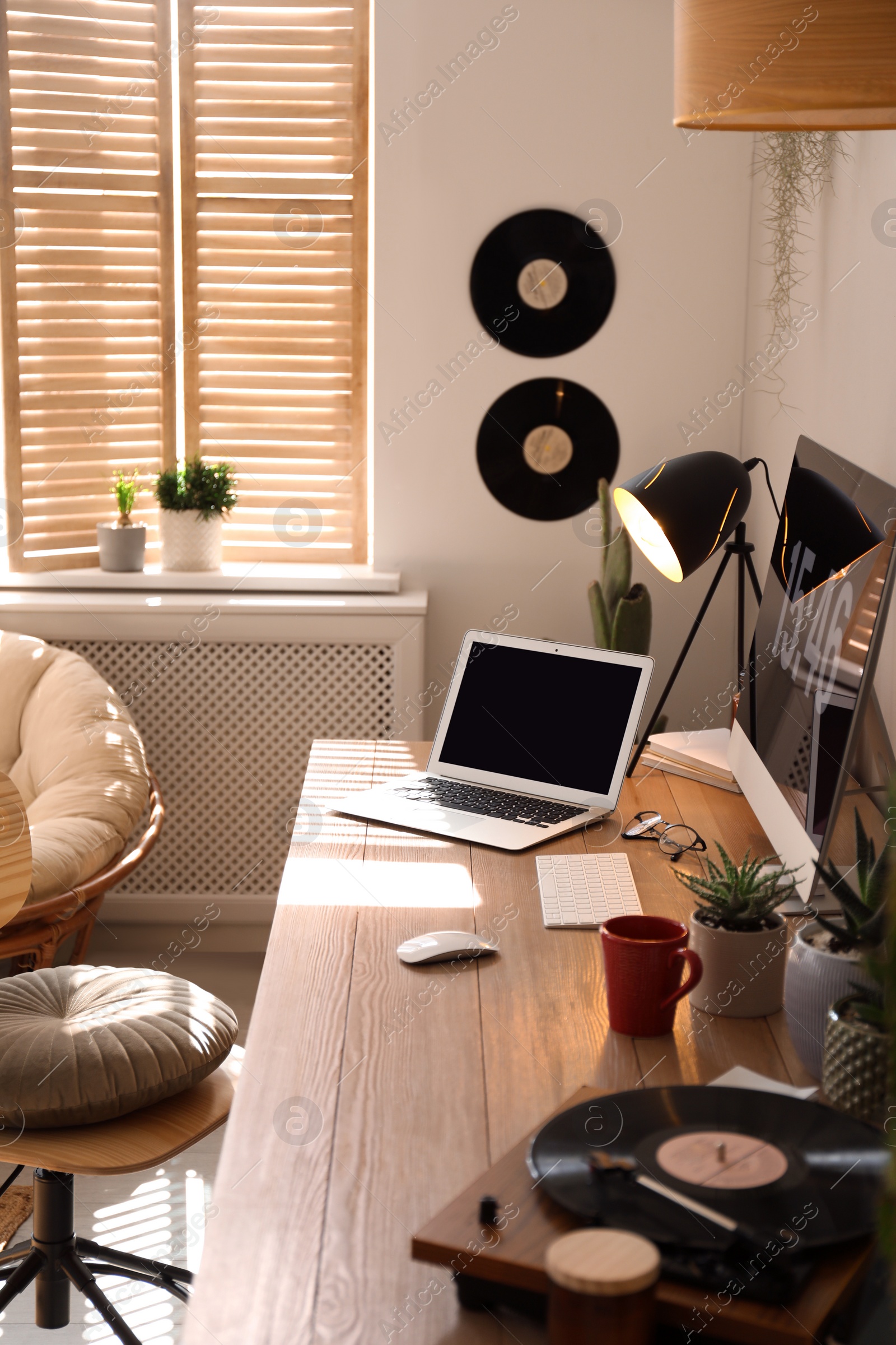 Modern computer and laptop on wooden desk in room. Interior design Photo of Modern computer and laptop on wooden desk in room. Interior design