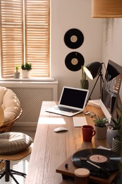Modern computer and laptop on wooden desk in room. Interior design Photo of Modern computer and laptop on wooden desk in room. Interior design