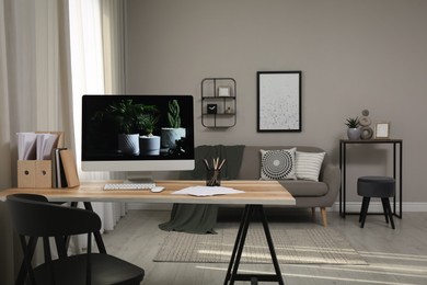 Comfortable workplace with computer on wooden desk in modern office. Interior design Photo of Comfortable workplace with computer on wooden desk in modern office. Interior design