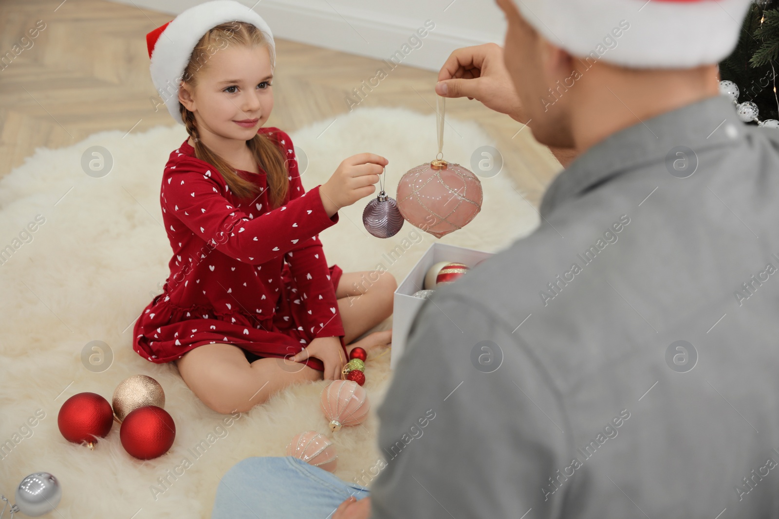 Father with his cute daughter decorating Christmas tree together indoors Photo of Father with his cute daughter decorating Christmas tree together indoors