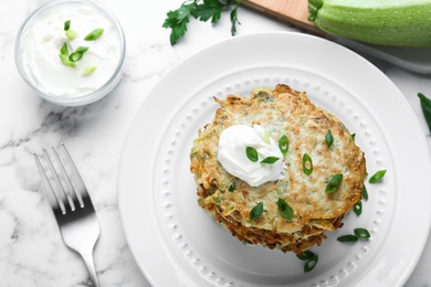 Delicious zucchini fritters served on white marble table, flat lay Photo of Delicious zucchini fritters served on white marble table, flat lay
