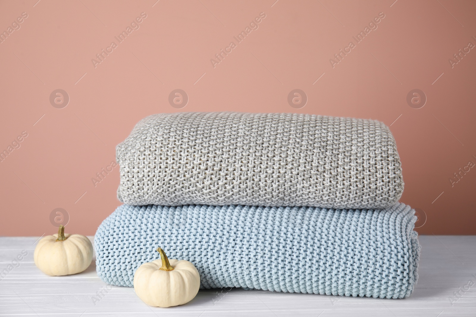 Soft plaids and small pumpkins on white wooden table, closeup Photo of Soft plaids and small pumpkins on white wooden table, closeup