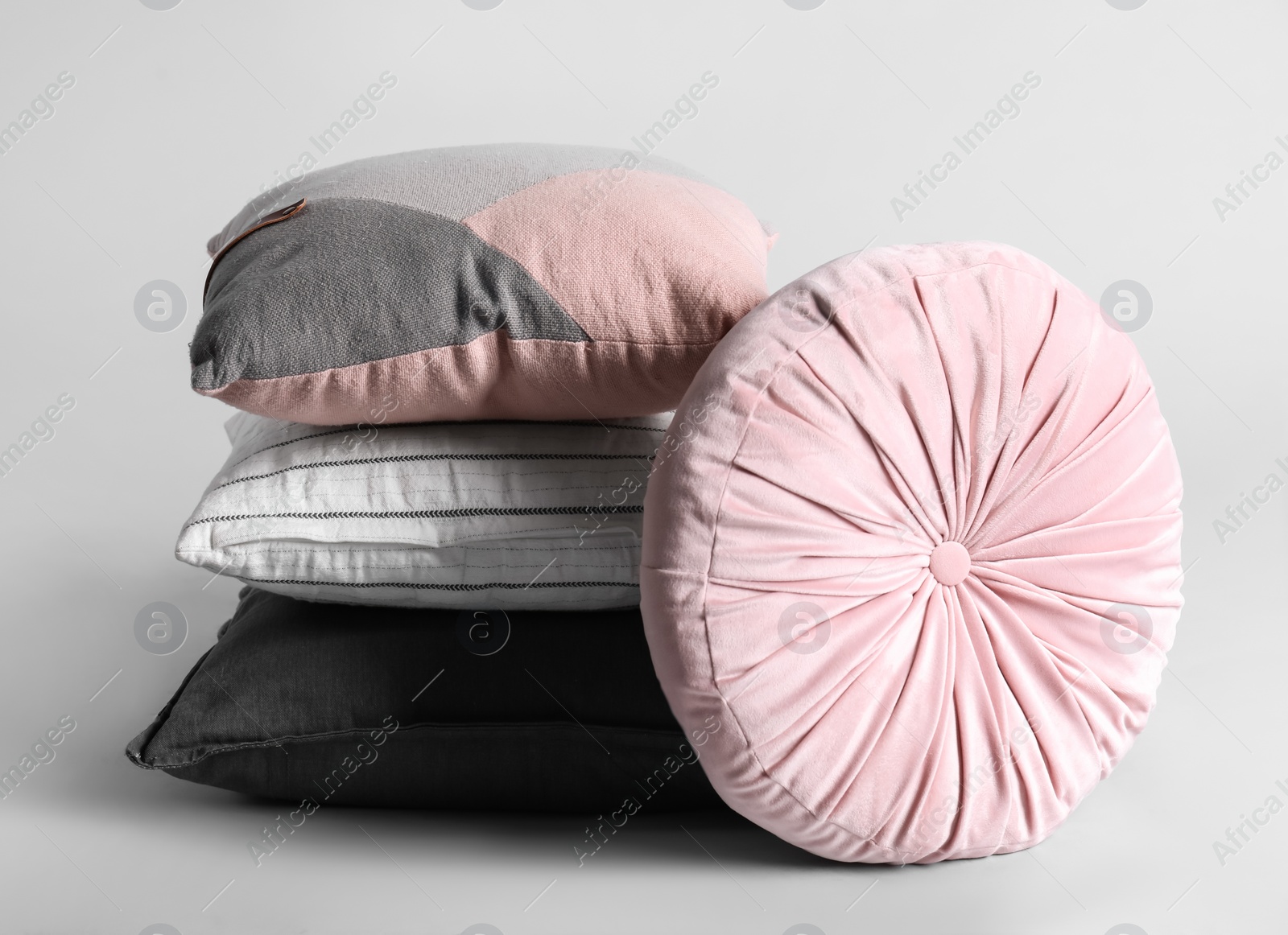 Different stylish soft pillows on grey background Photo of Different stylish soft pillows on grey background