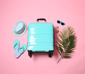 Photo of Flat lay composition with suitcase on pink background