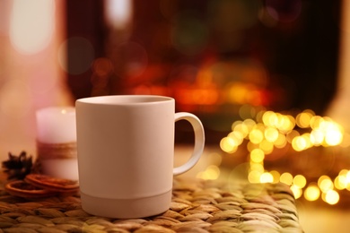 Cup of hot drink near fireplace at home. Space for text Photo of Cup of hot drink near fireplace at home. Space for text