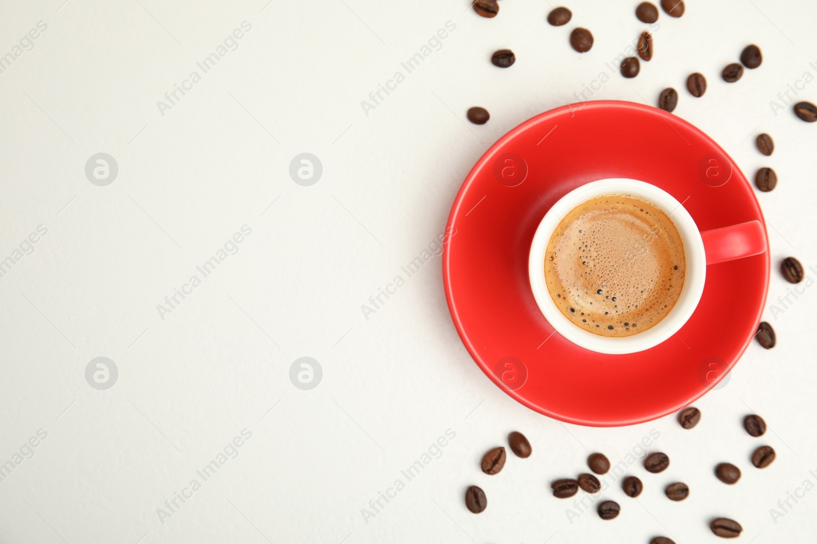 Cup of tasty coffee and beans isolated on white, top view. Space for text Photo of Cup of tasty coffee and beans isolated on white, top view. Space for text