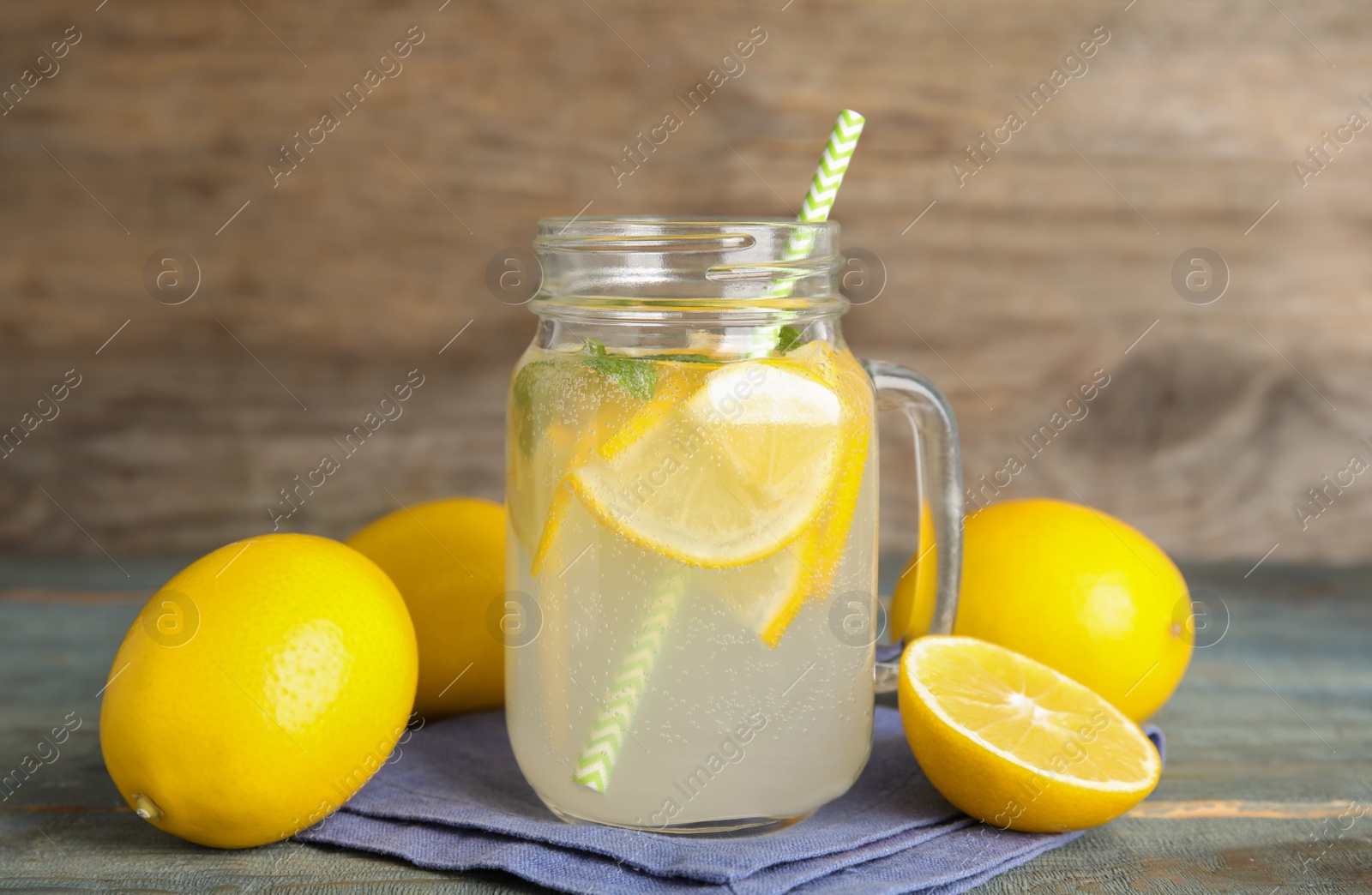 Cool freshly made lemonade and fruits on light blue wooden table Photo of Cool freshly made lemonade and fruits on light blue wooden table